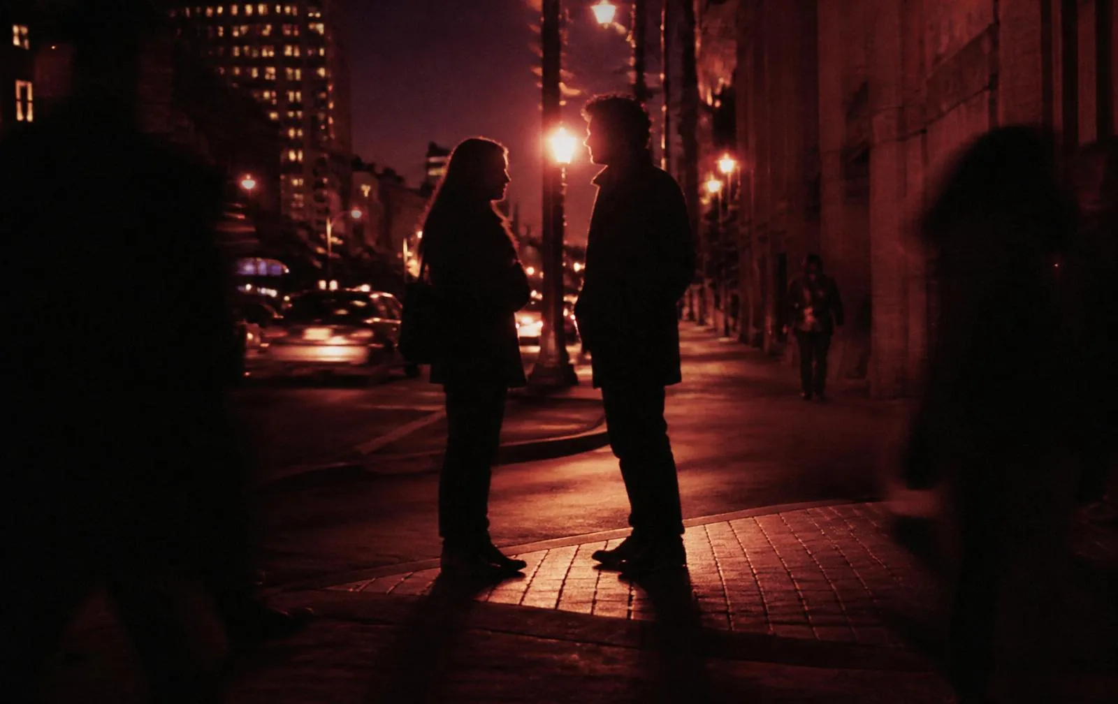 Two people talking on a city street at dusk during evangelism outreach